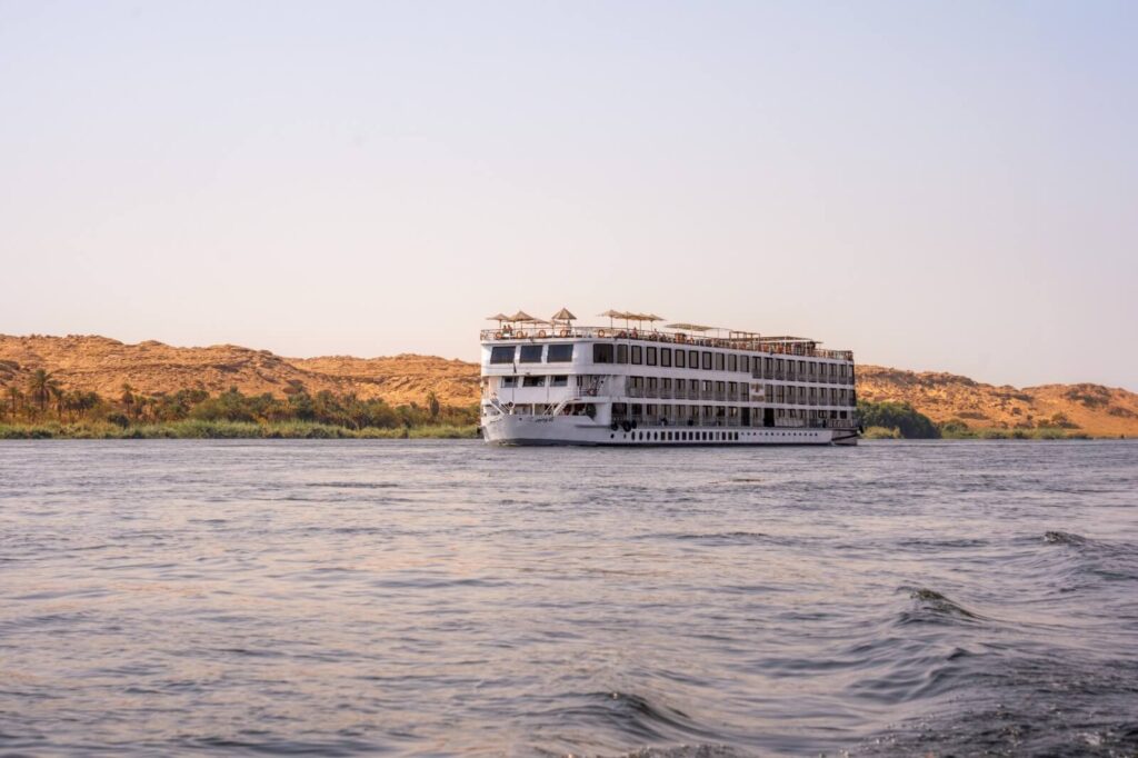 M/S City & Sea Adonis luxury Nile cruise ship anchored on the river with desert landscape.