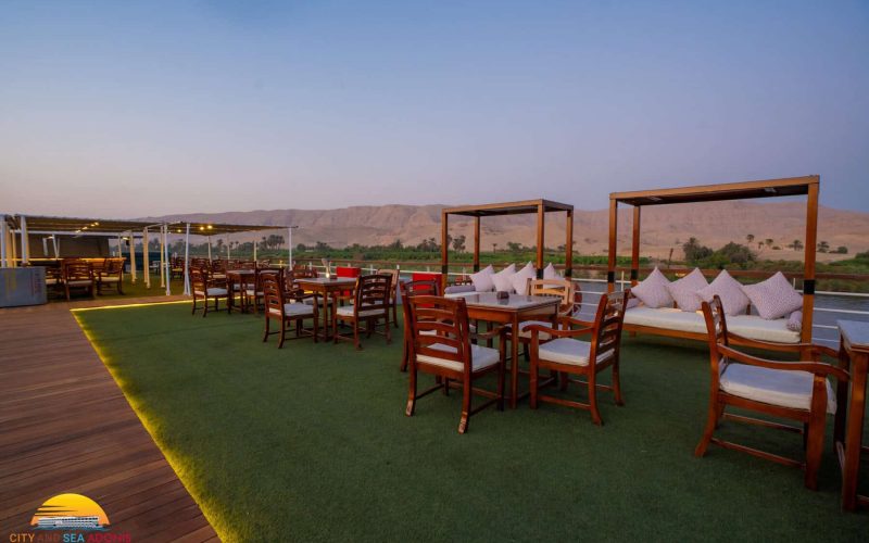Sun deck lounge and dining area aboard the M/S City & Sea Adonis with Nile Valley views.
