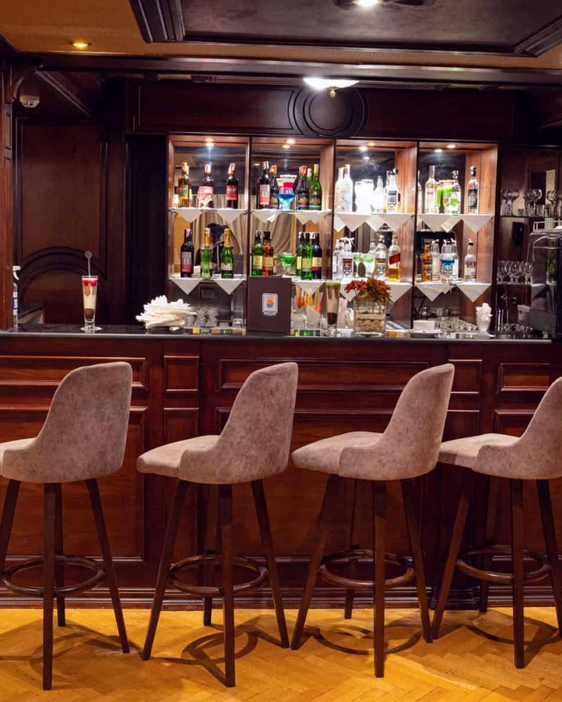 Elegant bar lounge aboard the M/S City & Sea Adonis with wood paneling and upholstered seating.