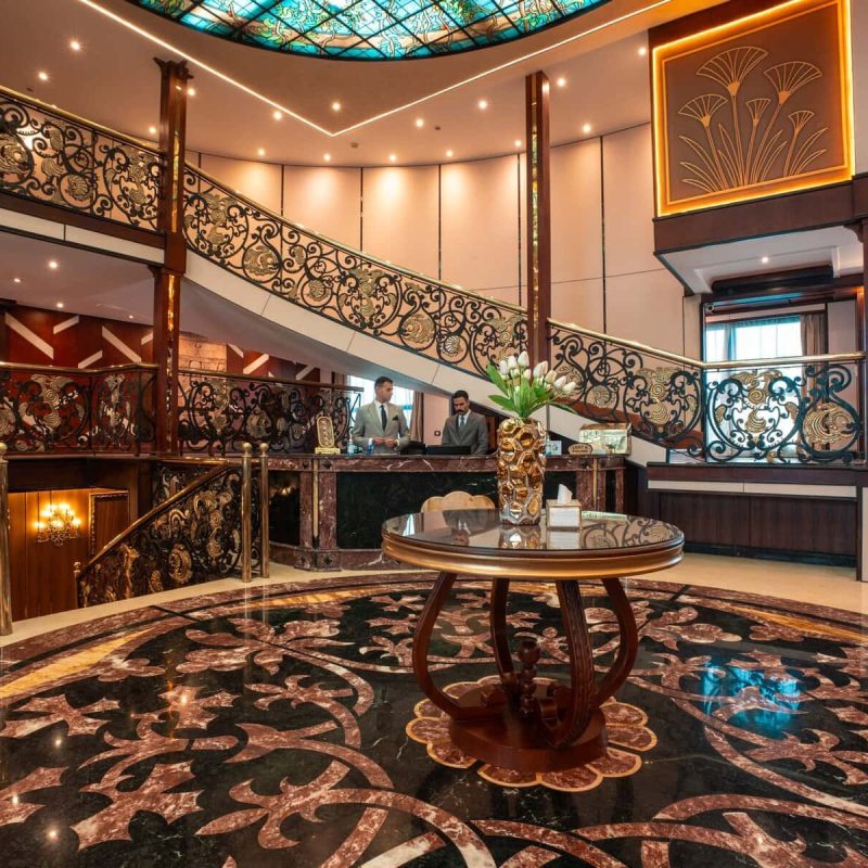 Elegant reception lobby aboard the M/S City & Sea Adonis with ornate staircase and Egyptian-inspired decor.