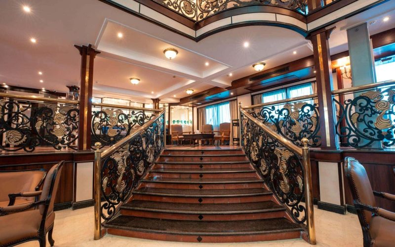 Grand staircase with ornate brass railings aboard the M/S City & Sea Adonis Nile cruise ship.