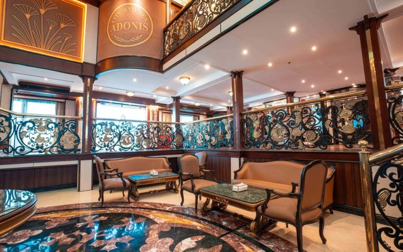 Elegant lounge aboard the M/S City & Sea Adonis with ornate railings and Egyptian-inspired decor.