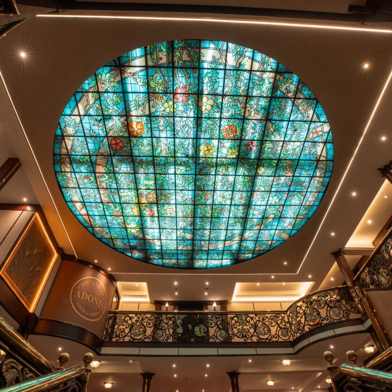 Ornate atrium ceiling aboard the M/S City and Sea Adonis with turquoise stained glass skylight.